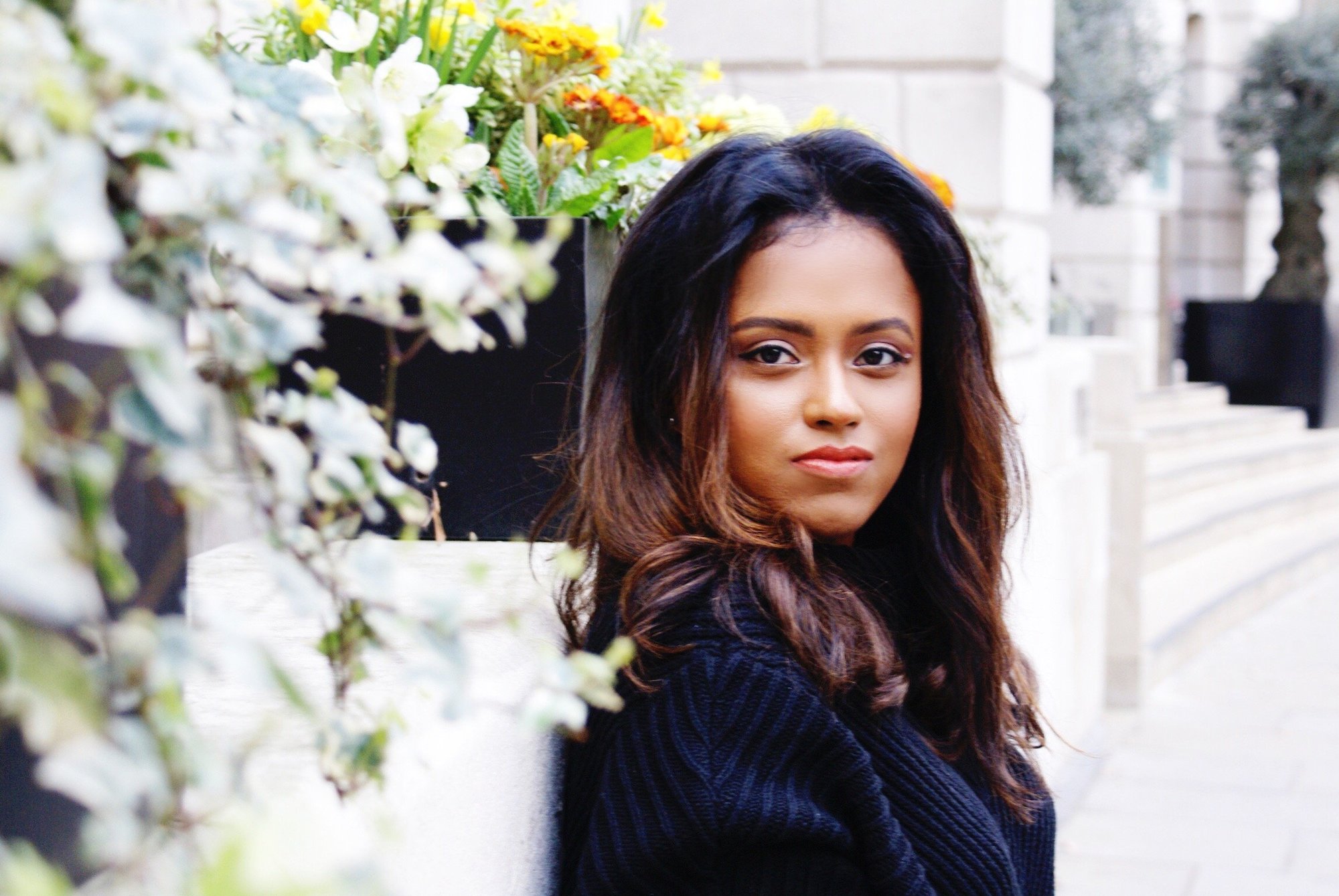 Sachini with a black top next to white flowers