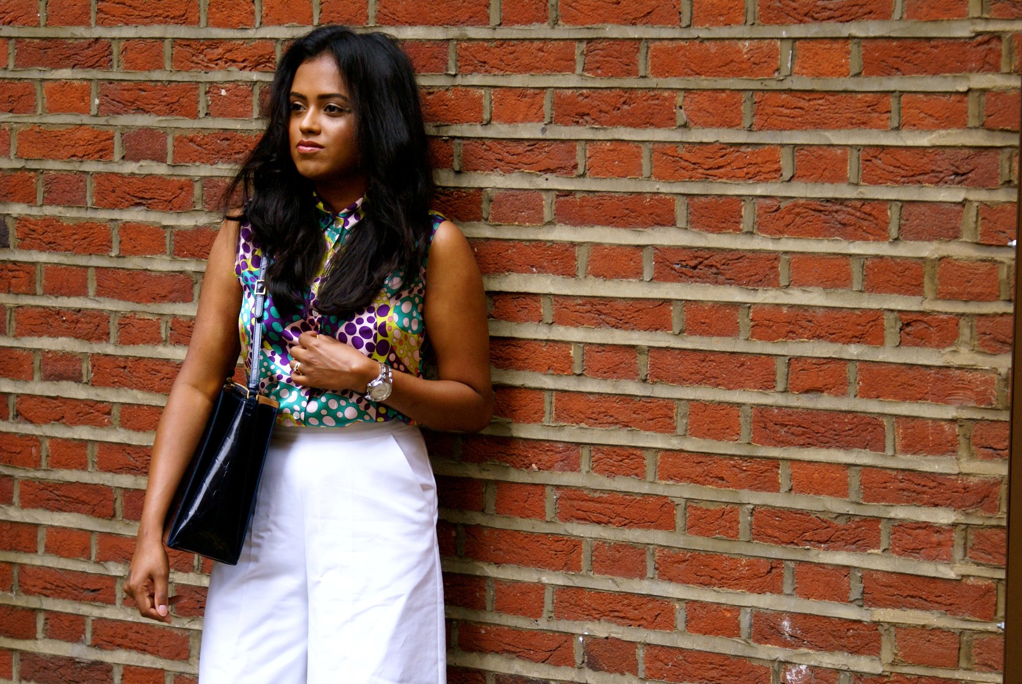 Sachini in front of a brick wall